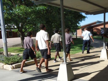 Image of detainess restrained by handcuffs moving between buildings with the Banksia Hill Detention Centre after the riot