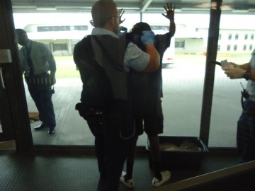 Image of a detainee being patsearched against a window at Hakea Juvenile Facility