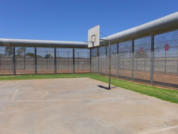 Photo of basketball court surrounded by security fence