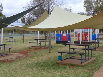 Photo of Min security visits area, picnic tables on grass under shade sails