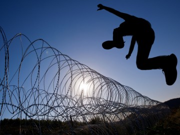 Man leaping razor wire