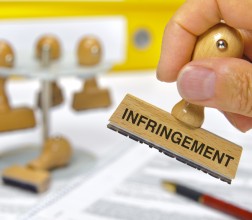 Image of a hand holding an infringement stamp