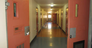 Image of a corridor with cells on either side at Acaica Prison