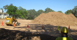 Image of a very large mound of earth, with an earth moving machine (Bobcat), used as a training area, Fairbridge Bindjareb Project.