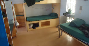 Image of beds, chair and shelves to renovated cell at Roeburne Regional Prison