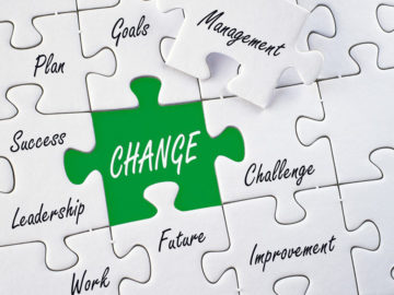 Image of a white jigzaw puzzle with words, and the word change in white with a green background