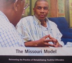 Image of two men talking, on front cover of report Missouri Model