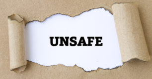 The word Unsafe shown through torn paper