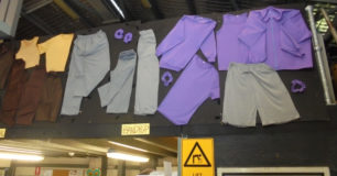 Production of prison clothing, displayed on boards above door in the textiles workshop