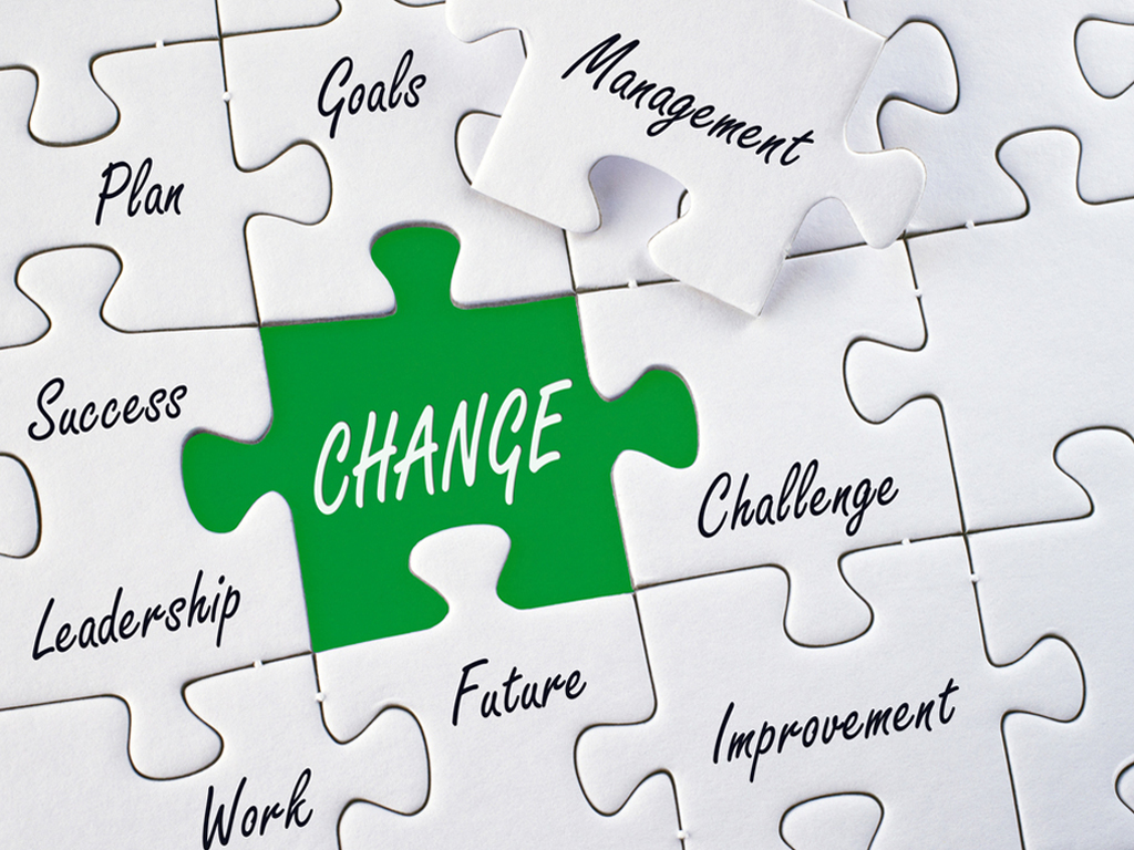 Image of a white jigzaw puzzle with words, and the word change in white with a green background