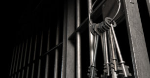 Image of set of keys dangling from lock in prison gate