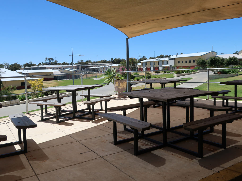 Image of tables and benches in outside area at Acacia Prison