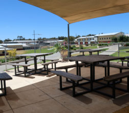 Image of tables and benches in outside area at Acacia Prison