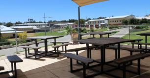 Image of tables and benches in outside area at Acacia Prison