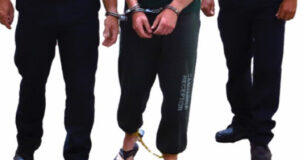 Image of a Prisoner handcuffed to a Prison Officer