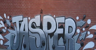 Graffiti art of the name 'Jasper' on wall in the basketball court