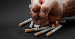 Image of a closed fist hitting a pile of cigarettes