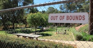 Image of outdoor visits area at Wooroloo with out of bounds sign on the fence