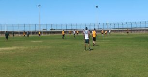 Image of prisoners playing a football match on the oval at Greenough Regional Prison, with no spectators