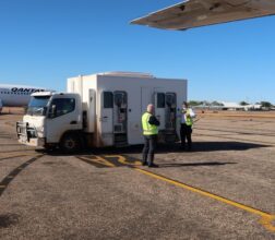 Image of a transport truck on airport tarmac ready to transfer prisoners