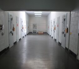 Image of cell doors in a row either side of a corridor in the SHU at Casuarina Prison
